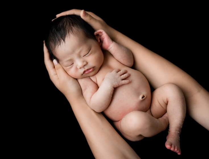 カラー写真の母の腕に抱かれた新生児