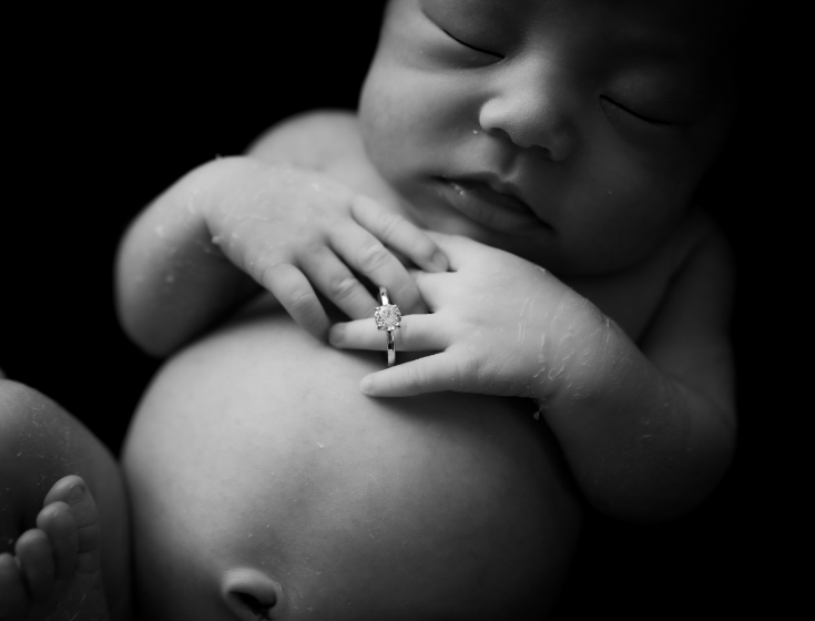 モノクロ写真の新生児と指輪